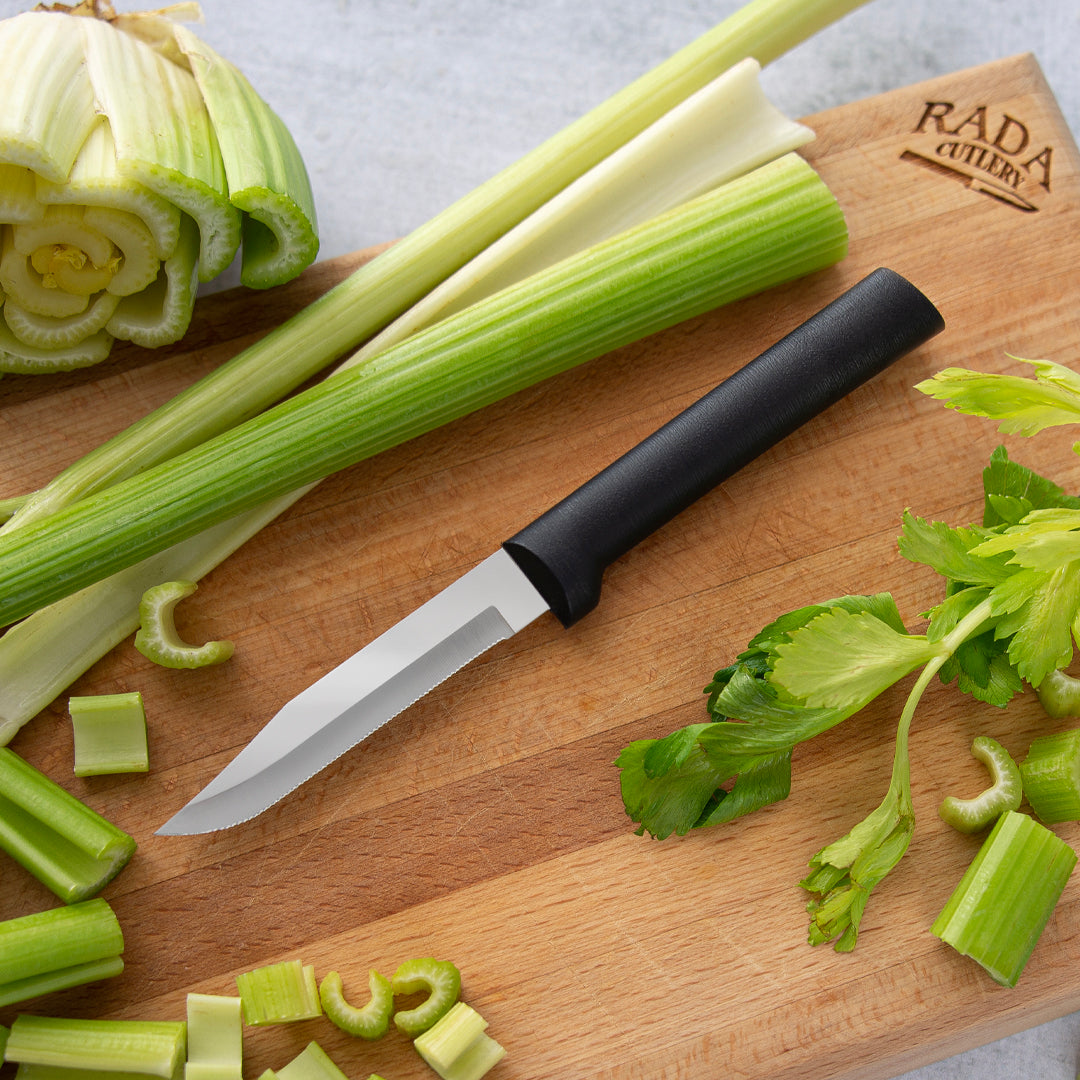 Handcrafted serrated paring knife with fine stainless steel blade and smooth black handle, made in USA, displayed on a wooden cutting board with sliced celery, ideal for Kitchen & Food and Farm, Garden & Tool collections.