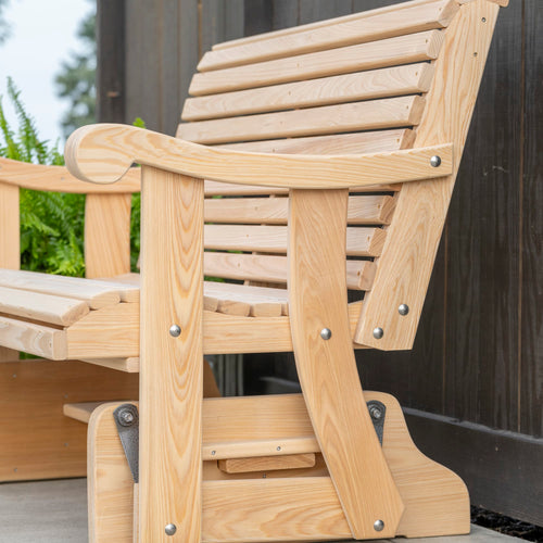 Close-up of a handcrafted cypress wooden glider swing with contoured back and curved armrests, showcasing natural wood grain and durable Amish-made outdoor furniture design.