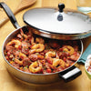 Stainless steel covered fry pan filled with seasoned shrimp and sausage dish, shown on wooden surface with spoon and glass, perfect for Kitchen & Food, Cookware, Pots and Pans collections.