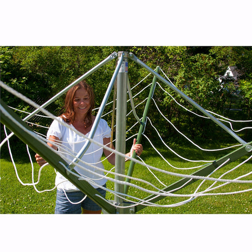 Woman adjusting a large handcrafted rotating clothes dryer with green canvas and metal frame in a sunny backyard, perfect for Home & Decor, Laundry Supplies, and Clothesline Accessories collections.