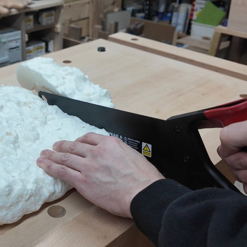 Spear & Jackson Predator insulation saw with carbon steel curved blade cutting expanding foam on wooden workbench, suitable for Farm, Garden & Tool and Hand Tools collections.