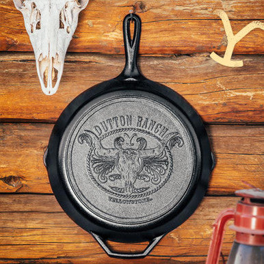 Back view of a handcrafted cast iron skillet featuring an embossed Dutton Ranch steer skull and rope emblem, made in USA, ideal for Kitchen & Food, Cookware, Cast Iron, USA Made, Best Sellers, and Promo Eligible collections.