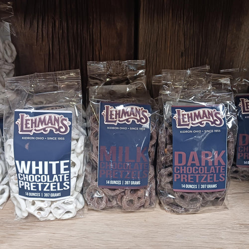 Three clear resealable bags of handcrafted Amish made chocolate covered pretzels in white, milk, and dark chocolate varieties, displayed on a wooden shelf, perfect for Kitchen & Food, Snacks and Sweets, Candy, USA Made, Best Sellers, and Promo Eligible collections.