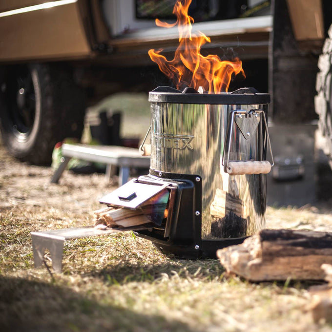 Portable stainless steel compact stove with wooden handle grips and front-loading firebox burning wood, designed for quick heat generation in Farm, Garden & Tool, Camping, Best Sellers, and Promo Eligible collections.