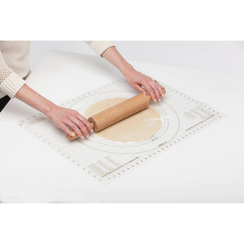 Person rolling dough on a clear non-slip baking mat with multiple crust size guides and measurement gridlines, ideal for Kitchen & Food and Baking Helpers collections.