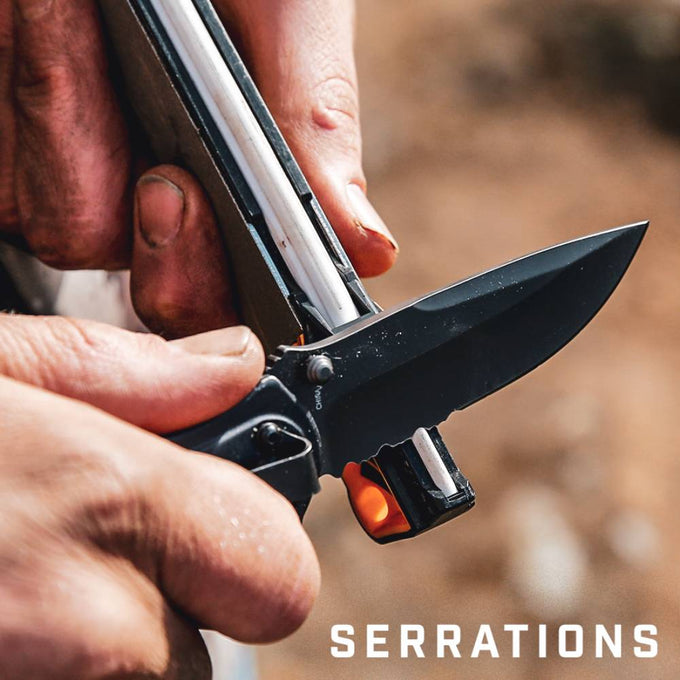 Close-up of a person using a compact guided sharpener with diamond and ceramic rods to hone the serrated edge of a black folding knife, perfect for Farm, Garden & Tool and Knives & Axes collections.