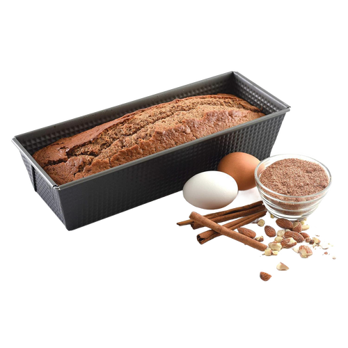 Rectangular heavy gauge steel loaf pan with nonstick textured surface showing baked bread inside, accompanied by eggs, cinnamon sticks, nuts, and a small bowl of brown flour for Kitchen & Food and Baking Supplies collections.