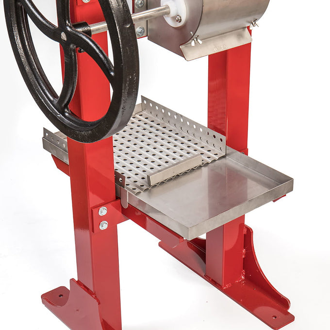 Close-up of a handcrafted cider press featuring a sturdy red frame, stainless steel pressing tray, and black cast iron crank wheel, designed for orchard and farm use in USA Made, Farm, Garden & Tool collections.