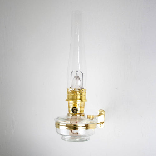 Clear glass and brass oil lamp mounted on a polished metal classic wall bracket, handcrafted for durability in Lamps & Lighting, Oil Lamps, Wall Lamps, and Best Sellers collections.