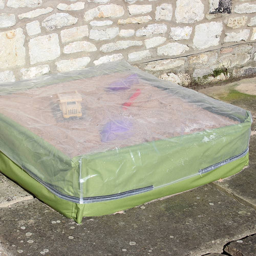 Raised green fabric sandpit with clear protective cover over sand and colorful toy tools, ideal for outdoor play, children's toys, garden accessories, and promo eligible collections.