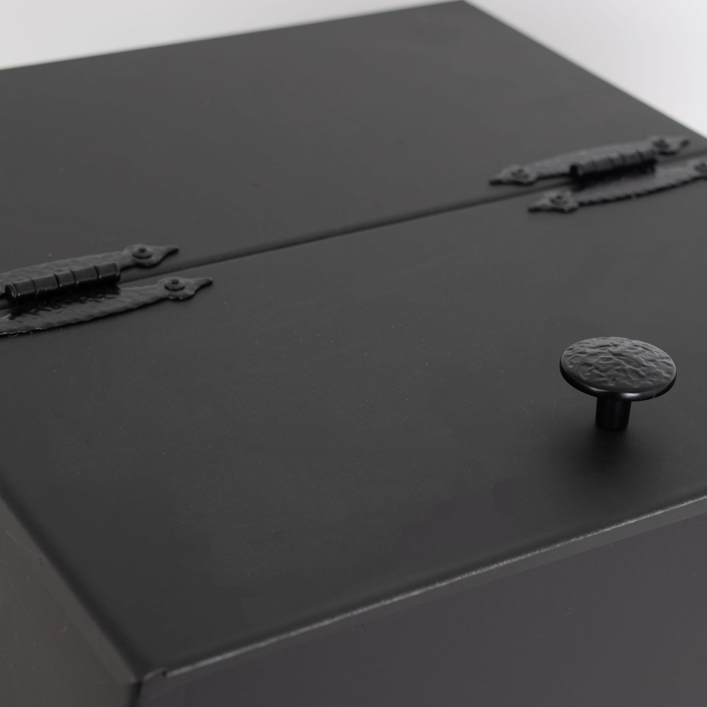 Close-up of a matte black steel ash carrier bucket lid with hammered metal knob and decorative hinges, handcrafted in USA for Hearth Accessories, Stoves, and Best Sellers collections.