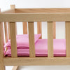 Miniature bedding set with pink pillow and mattress inside a handcrafted wooden doll cradle, highlighting Amish made quality for children's toys and doll accessories collections.