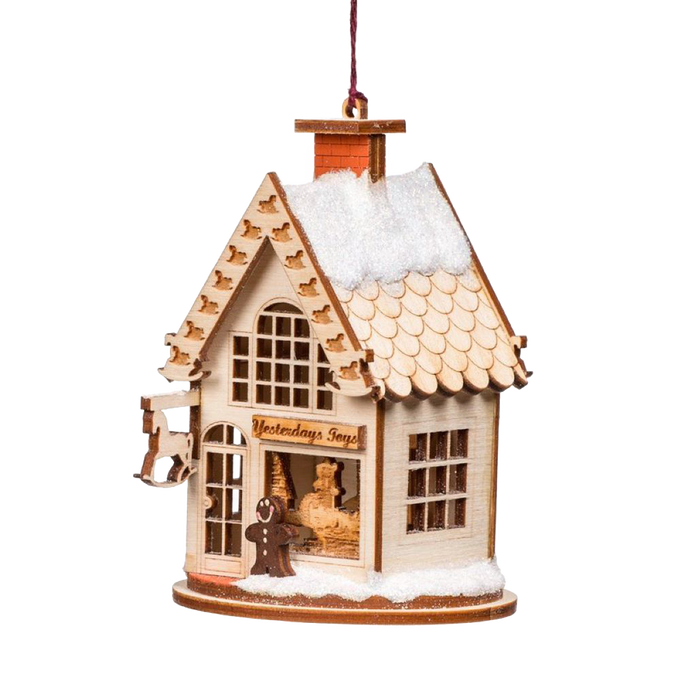 Handcrafted wooden holiday ornament shaped like a vintage toy shop with tiny rocking horses, snowy roof, and intricate details, perfect for Home & Decor and Holiday Decor collections.