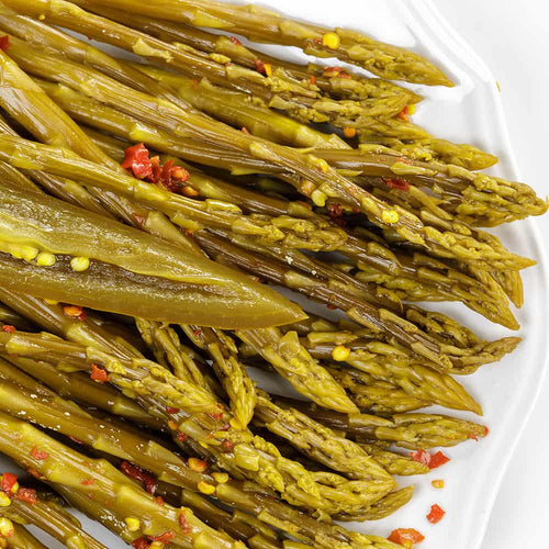 Close-up of handcrafted pickled asparagus spears seasoned with red pepper flakes, showcasing tangy flavor and Amish made quality, ideal for Kitchen & Food, Pantry, USA Made, and Best Sellers collections.