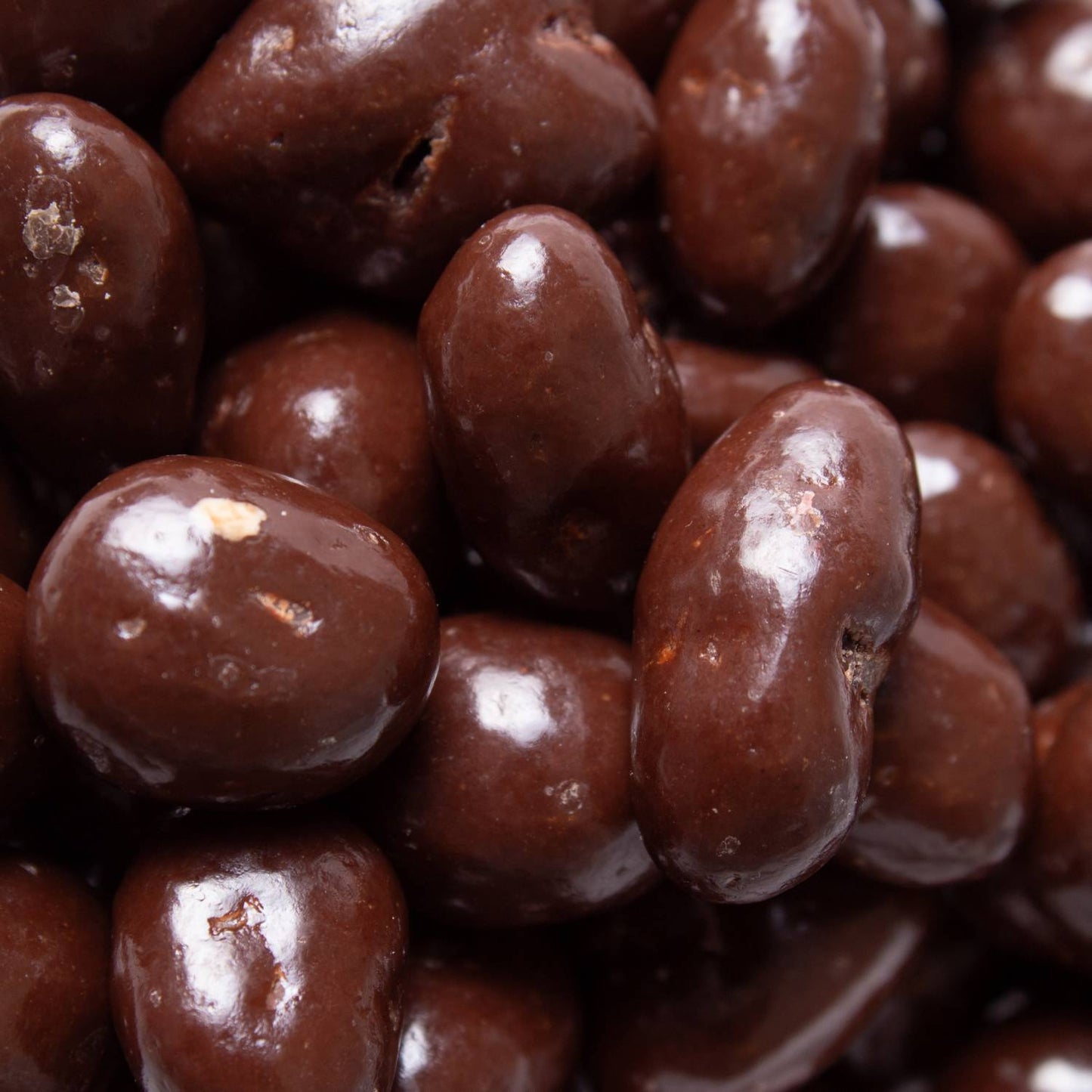 Close-up of glossy, handcrafted chocolate covered raisins made in USA, perfect for Kitchen & Food, Snacks and Sweets, Candy, USA Made, Best Sellers, and Promo Eligible collections.