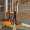 Handcrafted stainless steel shallow well pump mounted on a wooden countertop inside a rustic cabin, featured in Appliances, USA Made, Water Pumps, and Best Sellers collections.