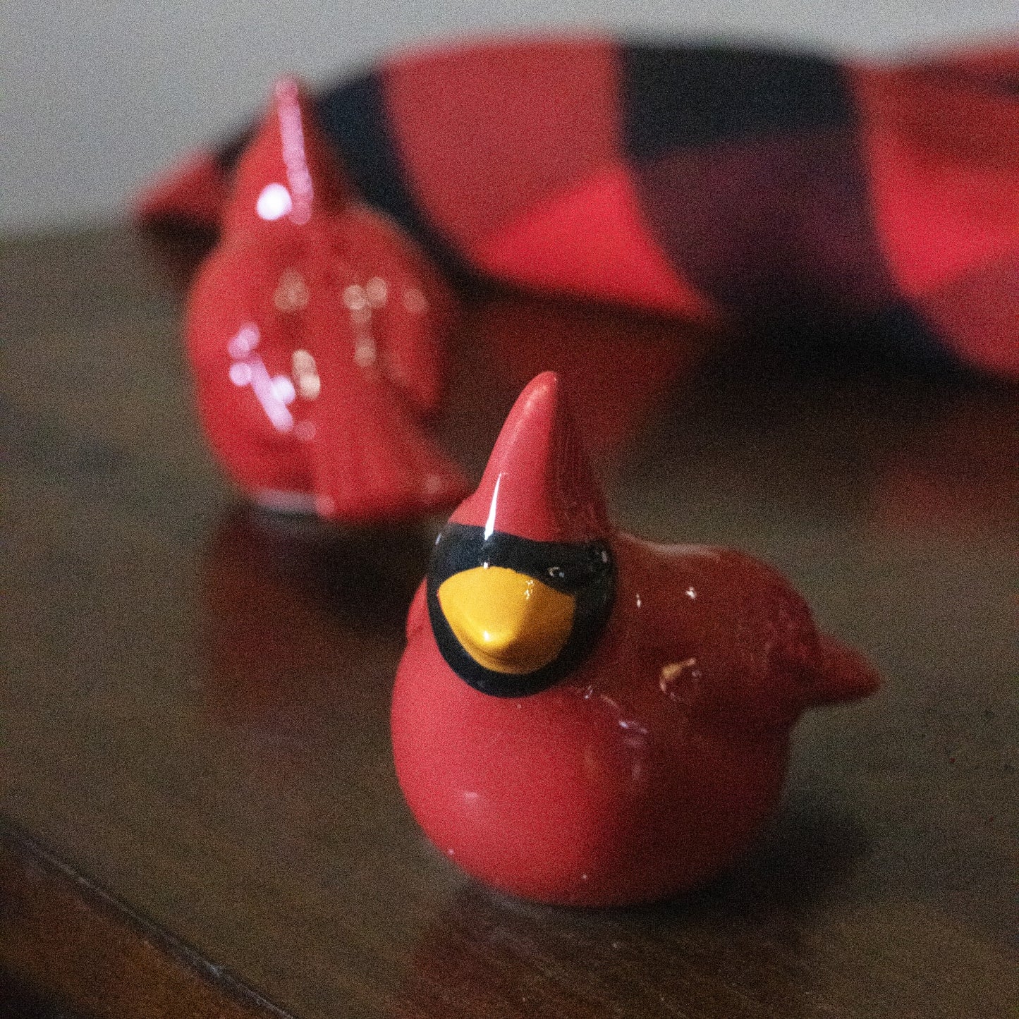 Set of two handcrafted earthenware cardinal shakers in red with black and yellow details, perfect for adding festive charm to Kitchen & Food and Dinnerware collections.