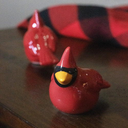 Set of two handcrafted earthenware cardinal shakers in red with black and yellow details, perfect for adding festive charm to Kitchen & Food and Dinnerware collections.