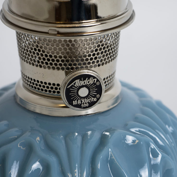 Close-up of a handcrafted Aladdin burner with perforated metal body and control knob on a glossy blue glass base, ideal for Lamps & Lighting, Oil Lamps, Table Lamps, Best Sellers, and Promo Eligible collections.