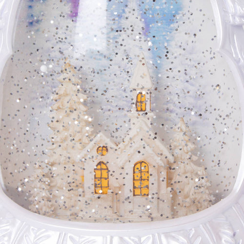 Lighted water globe featuring a snowy church scene surrounded by pine trees, creating a shimmering holiday ambiance, perfect for Home & Decor and Holiday Decor collections.