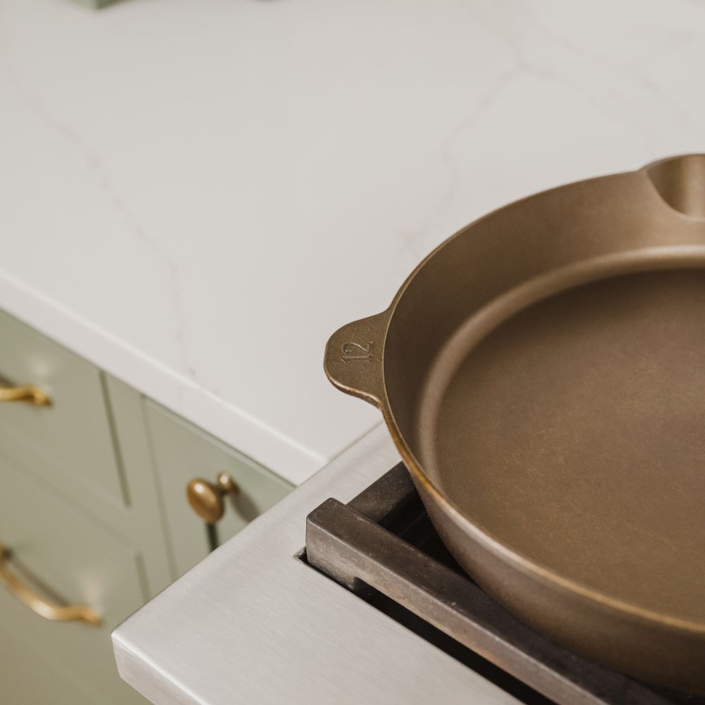 Close-up of a handcrafted, lightweight cast iron skillet with smooth cooking surface and marked size 12, resting on a gas stove in a modern kitchen, ideal for Farm, Garden & Tool, Kitchen & Food, Camping, Cookware, Cast Iron, USA Made, and Best Sellers collections.