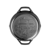 Handcrafted cast iron camper pan with dual handles, featuring a stamped campsite scene with camper, campfire, and trees, made in USA, perfect for camping and kitchen use.