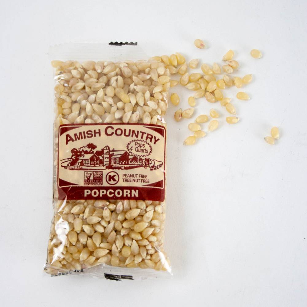 Clear plastic bag of handcrafted Amish Country popcorn kernels with a brown label, surrounded by loose yellow and white popcorn kernels, featured in Kitchen & Food and USA Made collections.