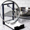 Compact two-in-one kitchen gadget with a plastic frame and white porcelain rest, designed to hold cooking spoons or securely prop pot lids, featured in Kitchen & Food and Kitchen Accessories collections.