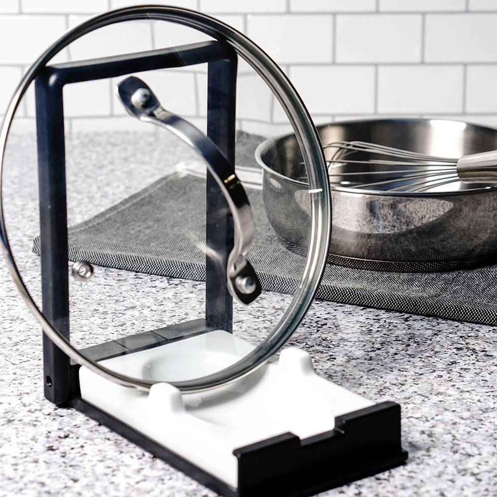 Compact two-in-one kitchen gadget with a plastic frame and white porcelain rest, designed to hold cooking spoons or securely prop pot lids, featured in Kitchen & Food and Kitchen Accessories collections.