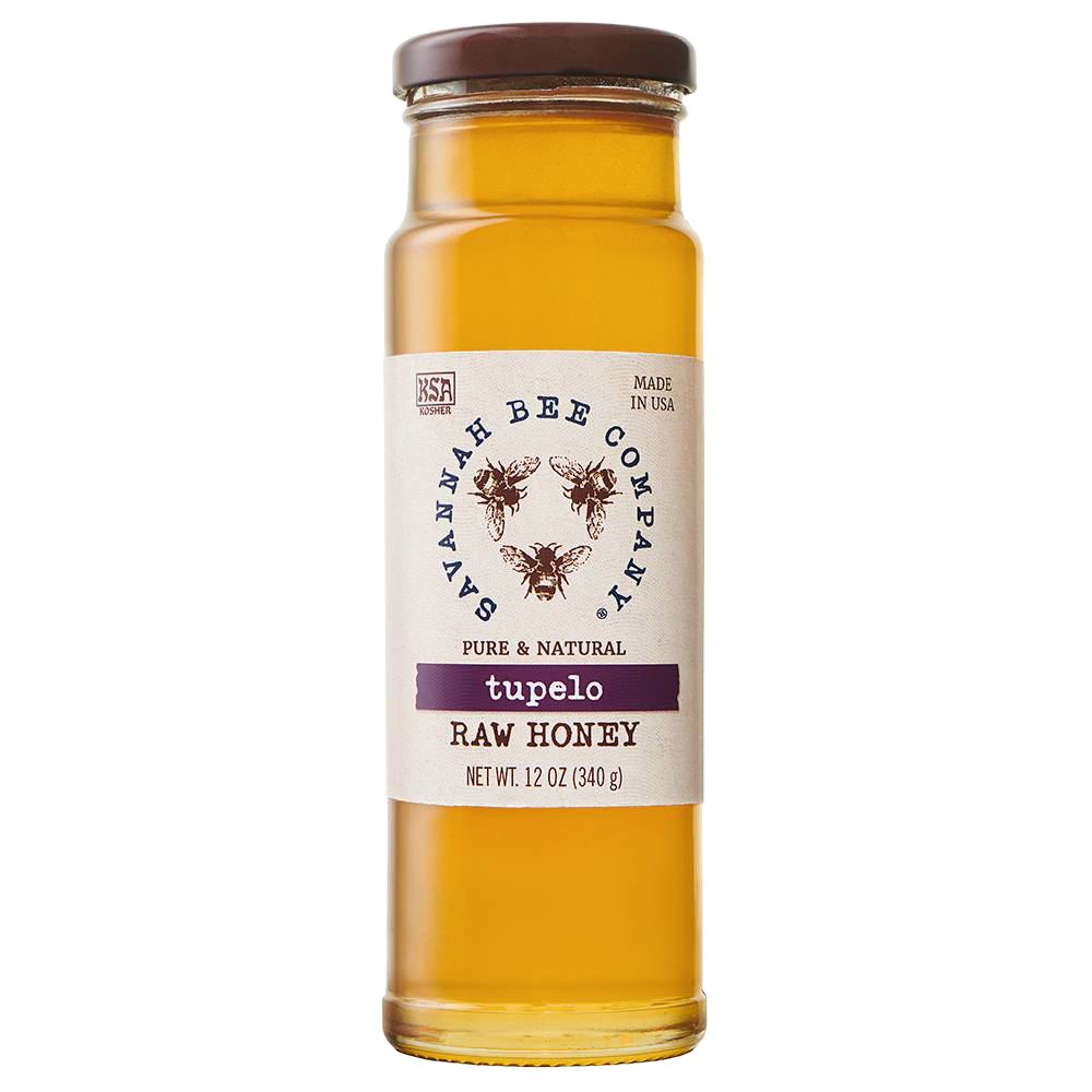 Tall clear glass jar of amber tupelo raw honey with a simple white label featuring bee illustrations and brown lid, perfect for Kitchen & Food, Pantry, and Best Sellers collections.
