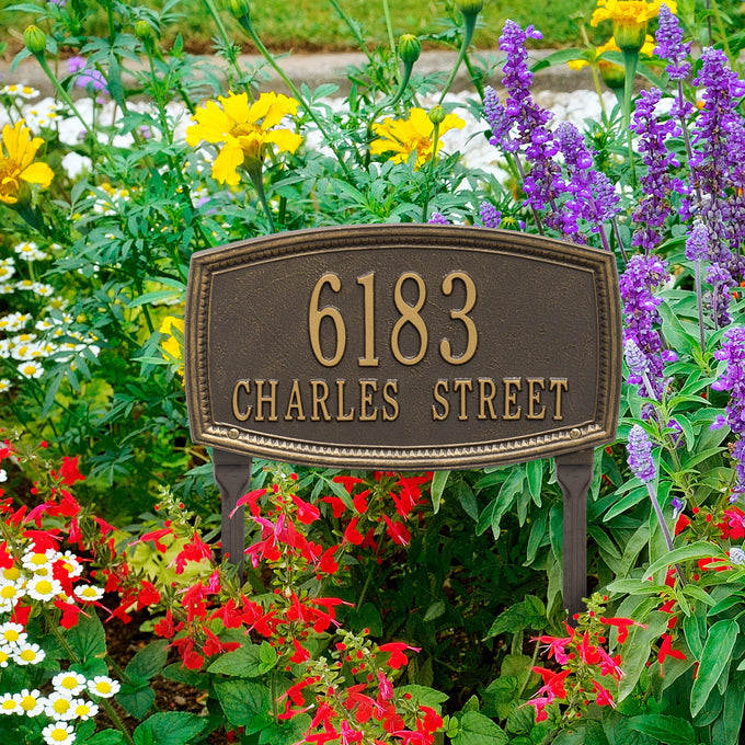 Custom bronze-colored address plaque with raised numbers and letters, set among colorful garden flowers, handcrafted and made in USA for Home & Decor and Mailboxes and Address Signs collections.