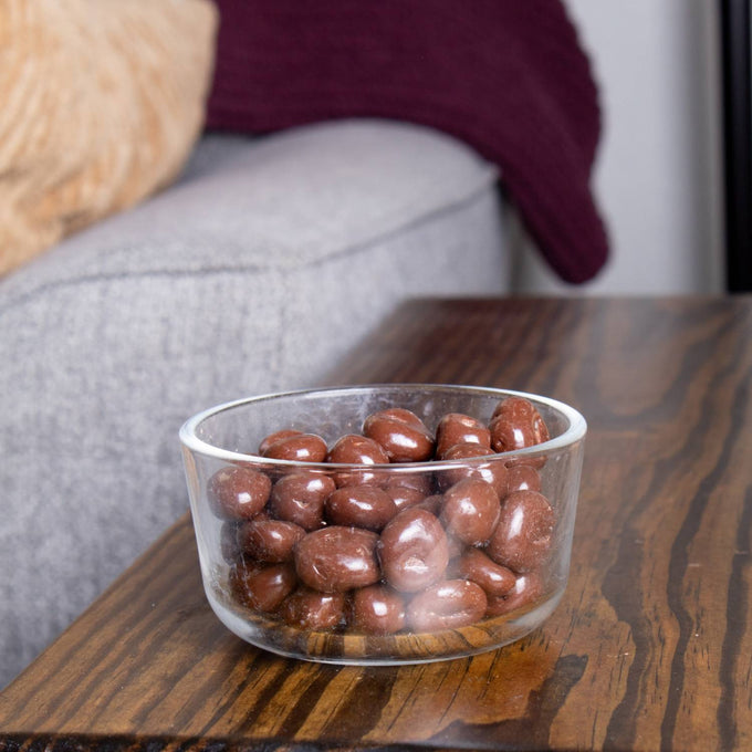 Clear glass bowl filled with handcrafted milk chocolate covered raisins, a USA made snack perfect for Kitchen & Food, Snacks and Sweets, Candy, Best Sellers, and Promo Eligible collections.