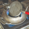Handcrafted Stovetop Krumkake Iron/Pizzelle Maker with aluminum base and red wooden handle heating over burner, featured in Kitchen & Food, Cookware, Baking Supplies, and USA Made collections.