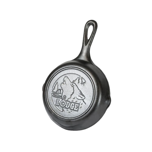 Small cast iron skillet with an embossed howling wolf and forest scene on the base, designed for Kitchen & Food, Cookware, Cast Iron, and USA Made collections.