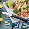 Paring knife with smooth black handle and sharp non-serrated blade, designed for precise peeling and cutting small foods, including avocados, made in USA for kitchen and food prep collections.