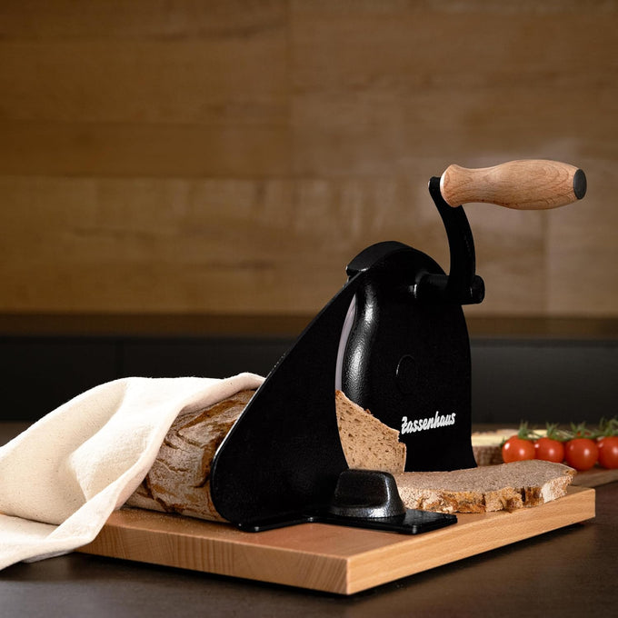 Manual bread slicer with easy hand crank and wooden handle slicing fresh homemade bread on a wooden cutting board, styled with tomatoes nearby, ideal for Kitchen & Food collections