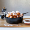 Handcrafted Lodge Blacklock cast iron deep skillet filled with golden, powdered sugar-dusted beignets, accompanied by coffee and chocolate sauce, featured in Kitchen & Food, Cookware, Cast Iron, USA Made, Best Sellers, and Promo Eligible collections.