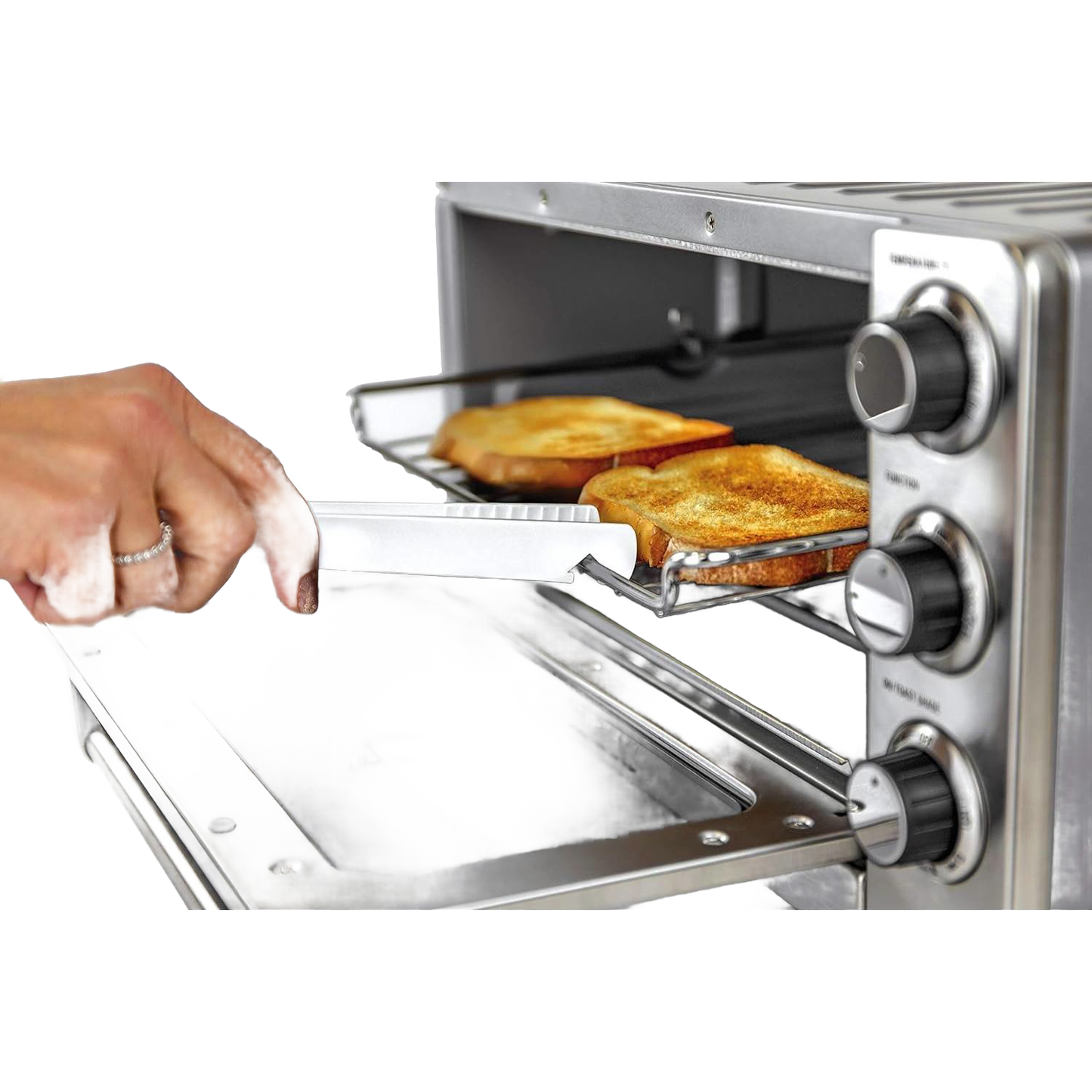 Hand holding white butterie toaster tongs with serrated teeth removing toasted bread from a stainless steel toaster oven, featured in Kitchen & Food and Kitchen Gadgets collections.