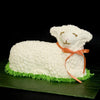 Handcrafted Easter lamb-shaped cake decorated with white frosting and an orange ribbon, styled on green icing grass, featured in Kitchen & Food, Cookware, Baking Supplies, USA Made, Best Sellers, Promo Eligible collections.