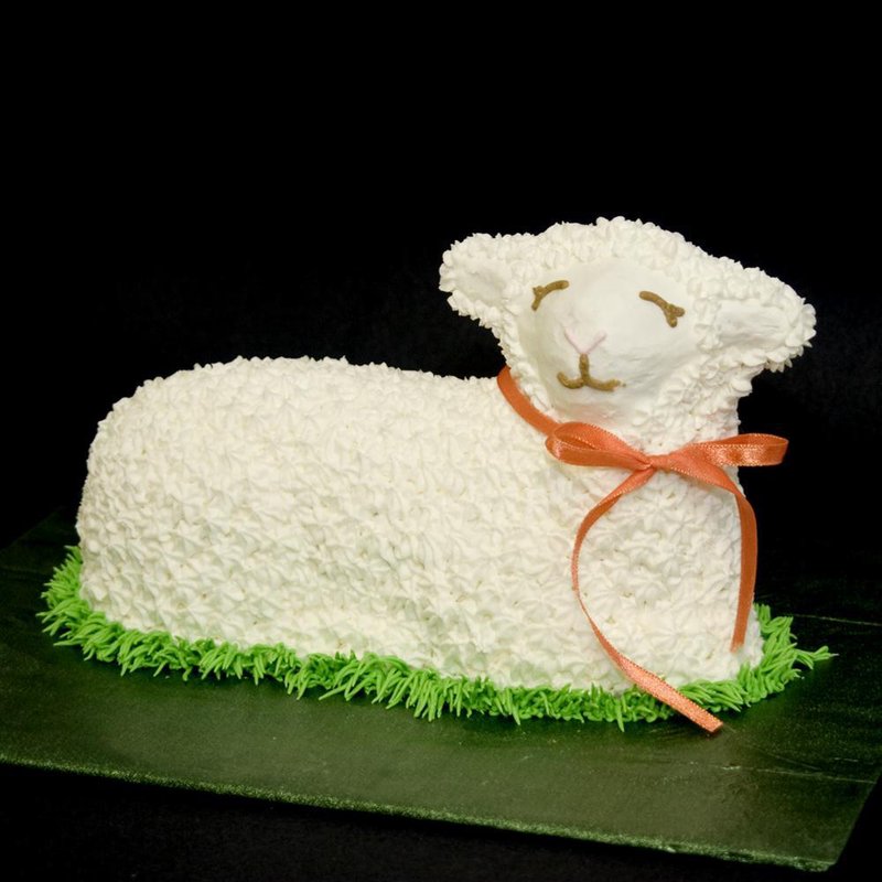 Handcrafted Easter lamb-shaped cake decorated with white frosting and an orange ribbon, styled on green icing grass, featured in Kitchen & Food, Cookware, Baking Supplies, USA Made, Best Sellers, Promo Eligible collections.