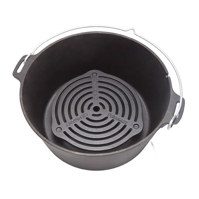 Solid cast iron grate with raised legs positioned inside a Dutch oven, designed for superior heat management during multi-level baking and roasting, ideal for camping and kitchen collections.