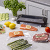 Automatic electric vacuum sealer preserving fresh salmon, asparagus, and steak in clear bags on kitchen countertop, featured in Kitchen & Food, Food Preservation, Freezing, Best Sellers, and Promo Eligible collections.