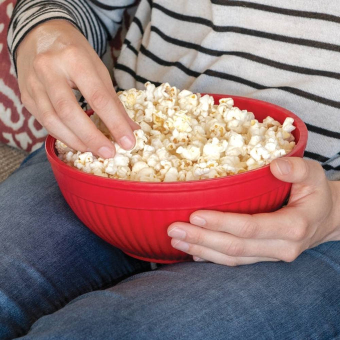 Person holding a red BPA-free microwavable popcorn bowl filled with freshly popped popcorn, suitable for Kitchen & Food, Popcorn, and Kitchen Gadgets collections.