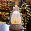Illuminated shimmering water globe shaped like a Christmas tree with a snowy church scene inside, featuring a 6-hour timer, perfect for home and holiday decor collections.