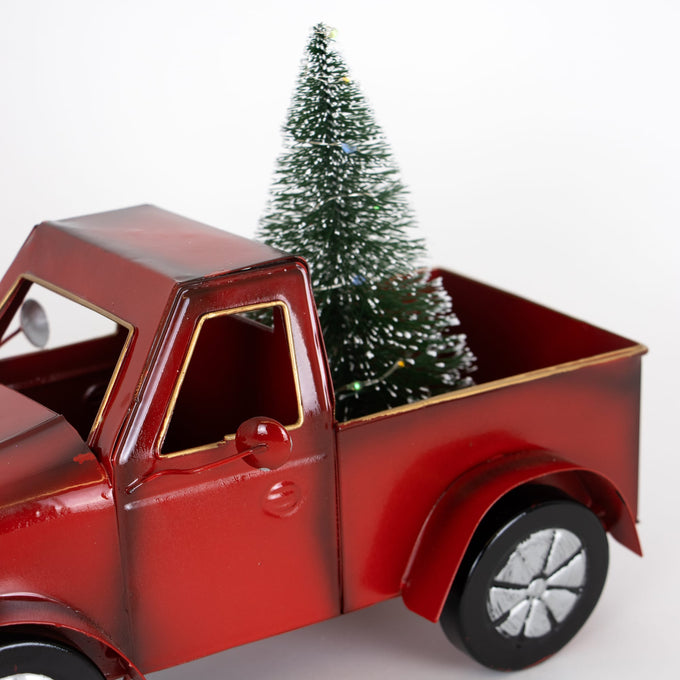 Handcrafted red metal holiday truck with a miniature green tree in its bed, featuring a nostalgic design perfect for Home & Decor, Holiday Decor, and Best Sellers collections.