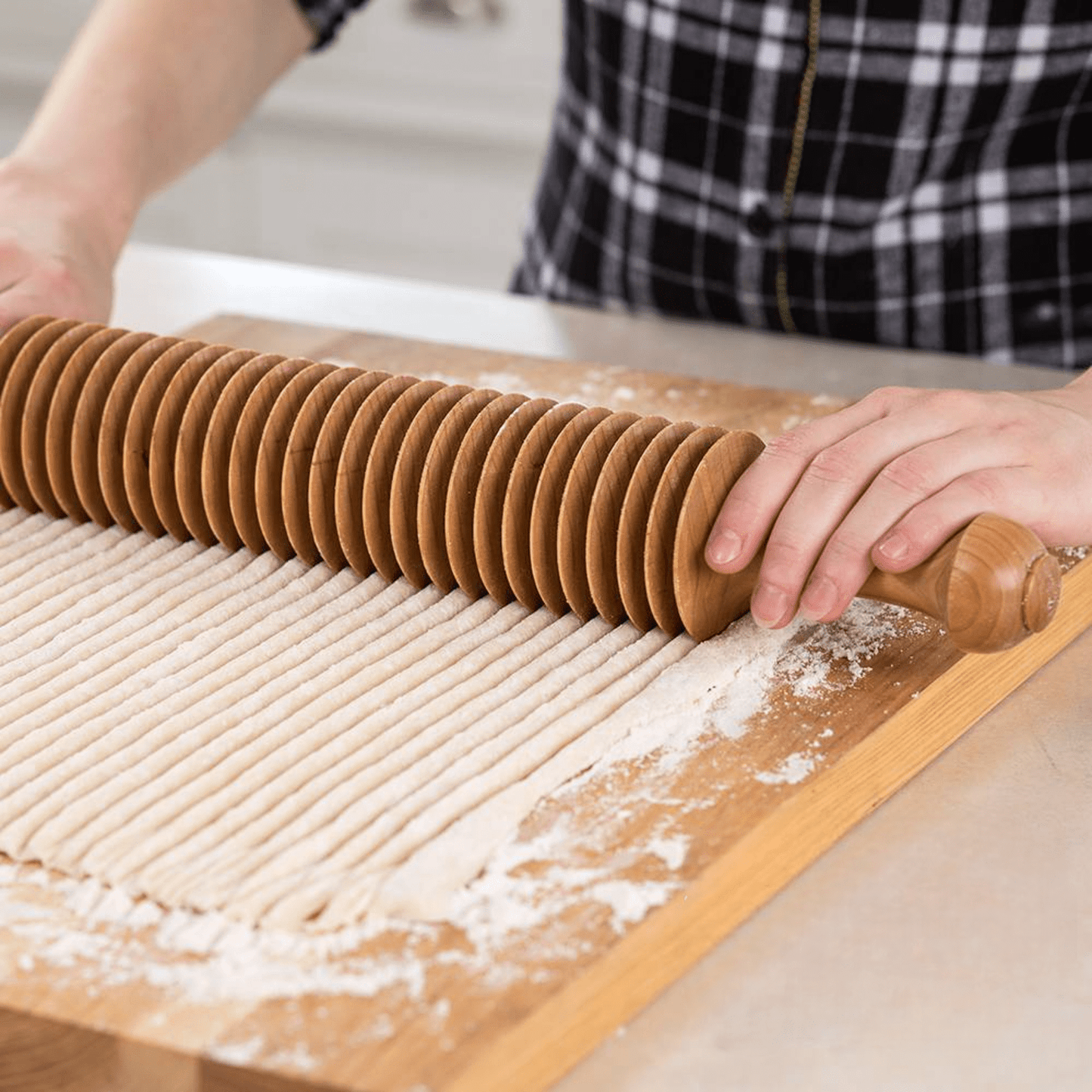 Handcrafted cherry wood noodle cutter rolling over dough to create evenly spaced, 3/8-inch wide noodle strips, ideal for Kitchen & Food, Food Prep, and Amish Made collections.