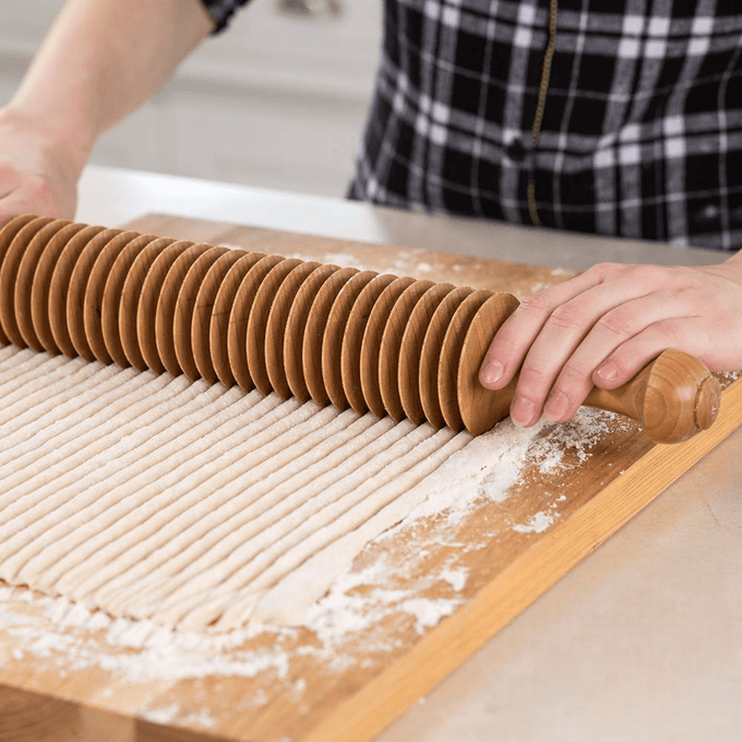 Handcrafted cherry wood noodle cutter rolling over dough to create evenly spaced, 3/8-inch wide noodle strips, ideal for Kitchen & Food, Food Prep, and Amish Made collections.