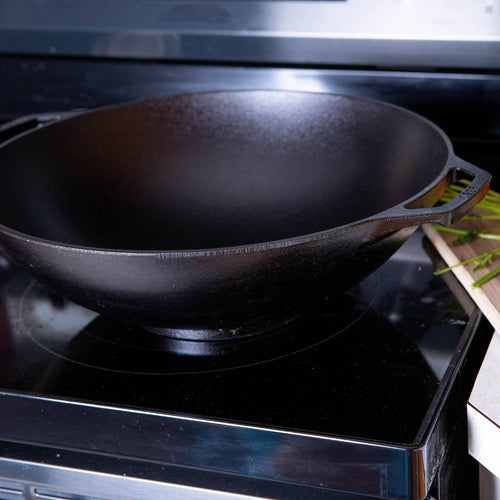 Black cast iron wok with wide flat base and side handle, designed for superior heat retention and balanced cooking, featured in Kitchen & Food, Cookware, Cast Iron, USA Made, and Best Sellers collections.