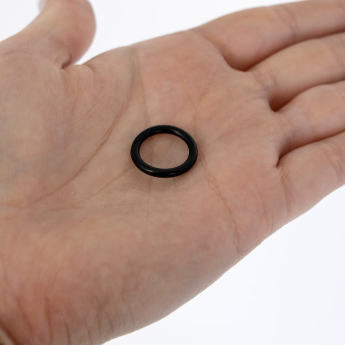 Small black rubber gasket ring resting on an open palm, designed for lamp filler plugs, featured in Lamps & Lighting and Parts and Accessories collections.