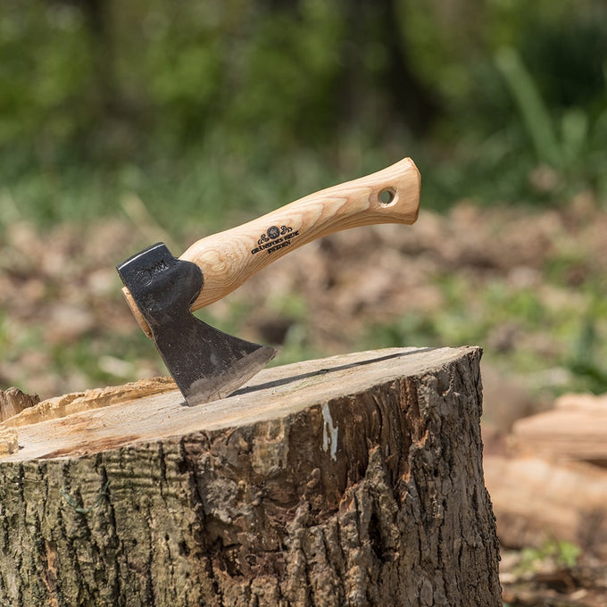 Compact handcrafted hand hatchet with tempered steel blade and smooth wooden handle embedded in a tree stump, ideal for Farm, Garden & Tool and Wood Cutting collections.